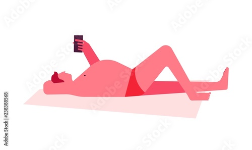 Man sunbathing lying on blanket on beach looking at cell