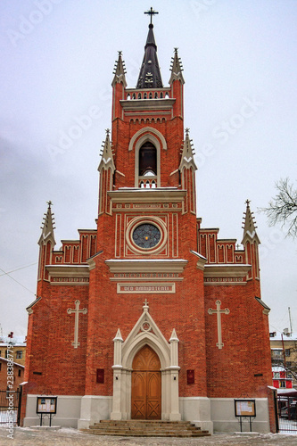The building of the Catholic church with crosses and spiers on a background of white clouds and a blue sky. Cathedral of the Assumption of the Blessed Virgin Mary, Kharkiv, Ukraine.