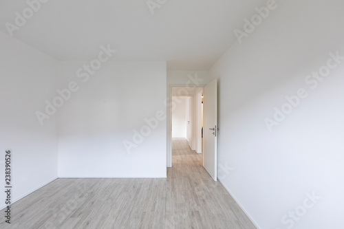 Empty room with white walls and open door on the right
