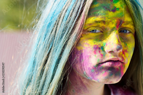 Dry color on face. Colorful holi on painted hair and face. Girls with colorful hair and face enjoing in the moment. Dry color concept. Happy life in teenager time. photo