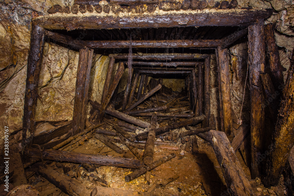 Underground abandoned gold iron ore mine shaft tunnel gallery passage wtih wooden timbering Underground abandoned gold iron ore mine shaft tunnel gallery passage wtih wooden timbering