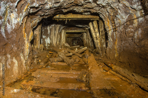 Underground abandoned gold iron ore mine shaft tunnel gallery passage wtih wooden timbering