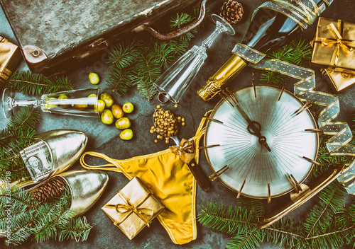 LATIN AMERICAN AND SPANISH NEW YEAR TRADITIONS. empty suitcase  lentil spoon  yellow interior clothes  gold ring in champagne  12 grapes  money in shoe. Christmas background