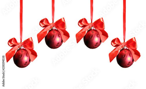 four red hanging christmas balls with ribbons