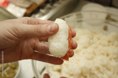 Man hand preparing nigiri sushi from rice and tuna fish and wasabi.Close up of chef hands making rolls of nigiri sushi.