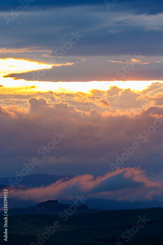 Sunset with colorful clouds in a mountainous landscape