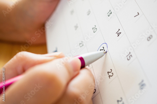 calendar page with female hand holding pen