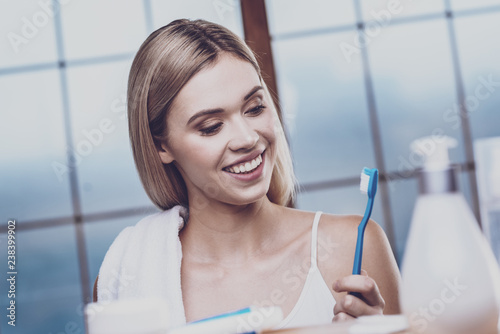 Optimistic woman looking at the toothbrush