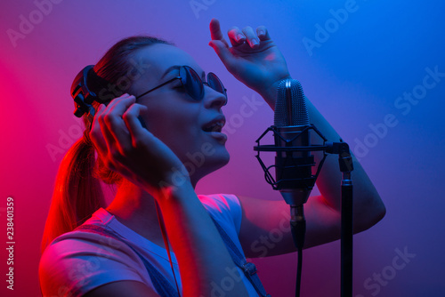 Young beautiful girl records vocals, show business, DJ, party, pop music