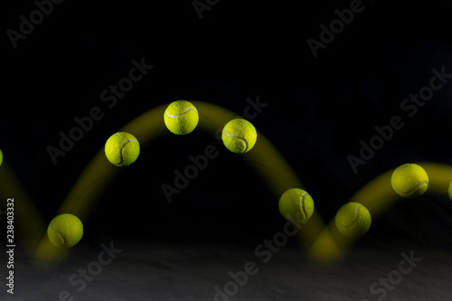 Tela Movement or bounce of tennis ball isolated on black background.