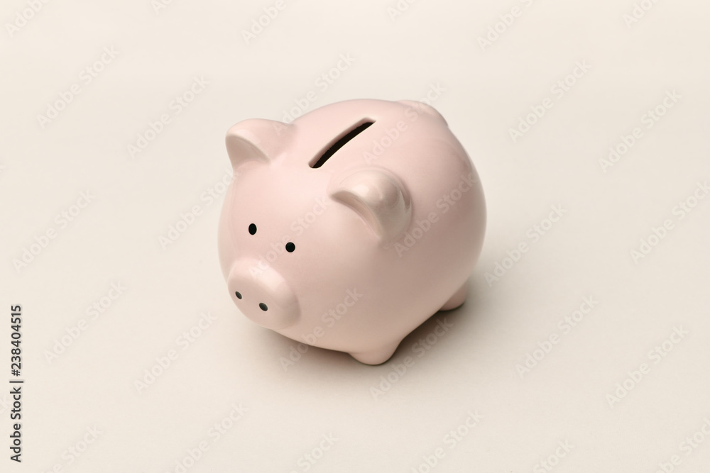 .Pink piggy Bank stands on a gray background with a shadow. Horizontal photography.