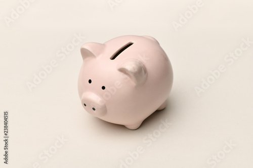 .Pink piggy Bank stands on a gray background with a shadow. Horizontal photography.