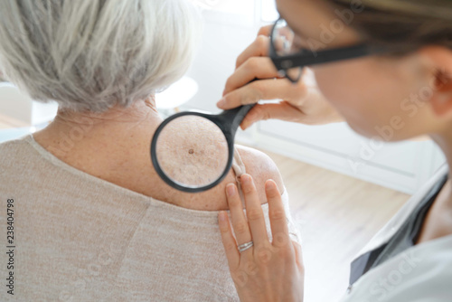  Senior woman getting skin checked by dermatologist