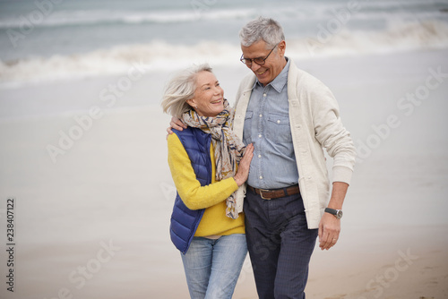  Happy senior couple walking together on the beach