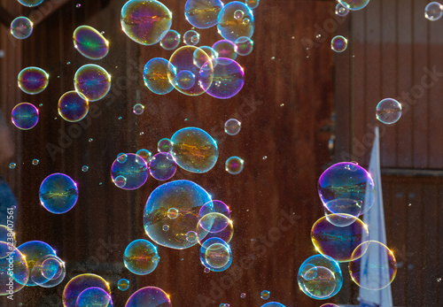 Many soap bubbles in air on city street, outdoor fun for everybody