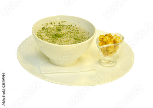 Soup-puree on a platter with crackers on a white background