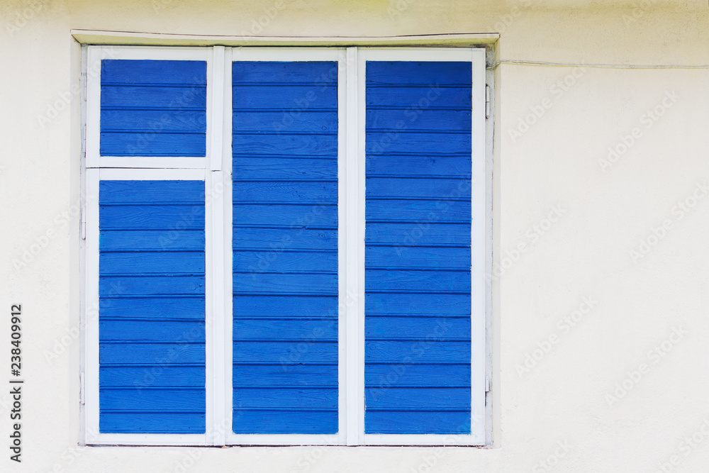 Fototapeta premium The old window is painted blue. The wire is on the wall.