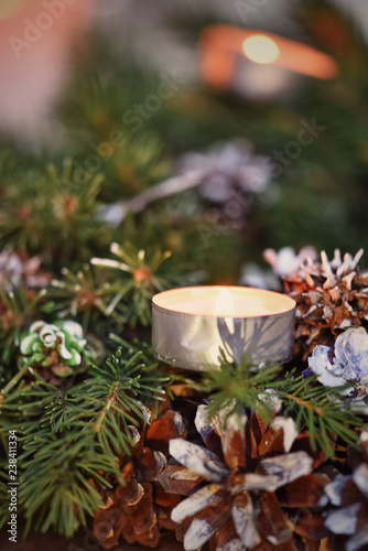 Advent decoration, wreath, candle. In the dark a candle in a beautiful decorative wreath is burning.