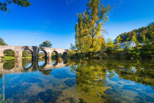 Croatian countryside, old stone bridge over the Dobra river in Novigrad, Karlovac county, beautiful landscape photo