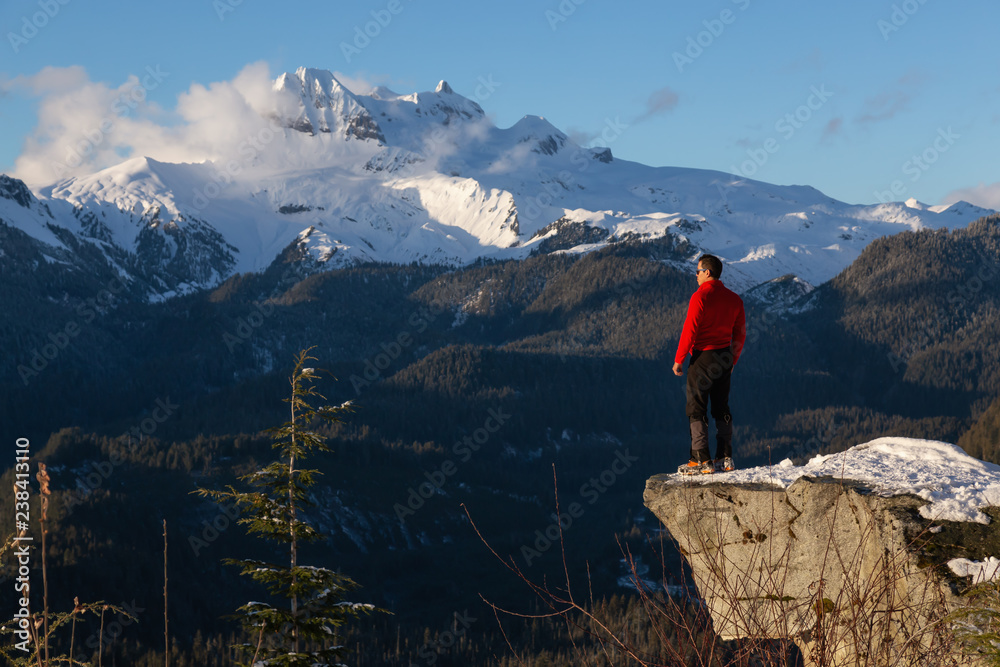 Adventurous Man enjoying the beautiful Canadian winter landscape during a bright sunny day. Taken on a hike to Watersprite Lake, near Squamish, North of Vancouver, BC, Canada.