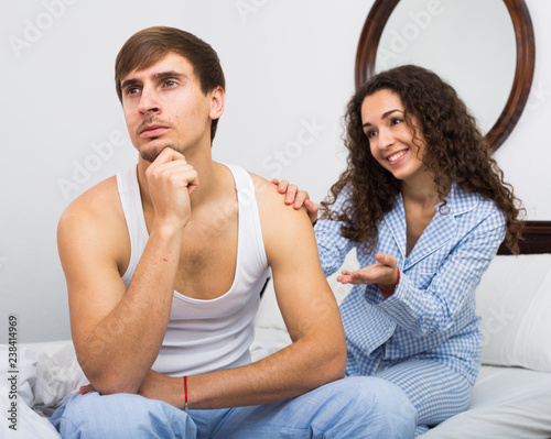 Smiling girl trying to comfort upset husband