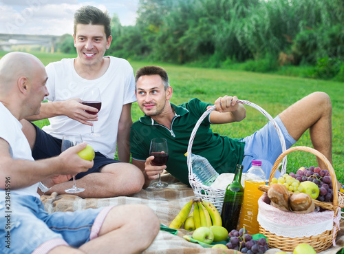 Three friends enjoying life on picnic outdoors © JackF