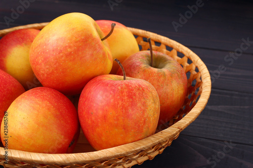 Red apples Pinova in a plate on a dark background photo