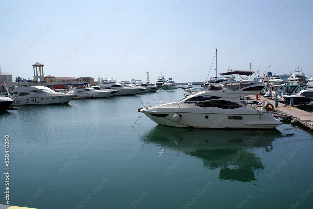 Yachts, boats at the pier in the seaport.