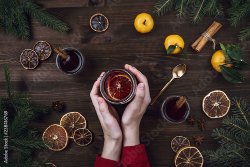 Flatlay of woman's hands holding glass with mulled wine