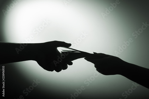 dark economy. Two hands with money