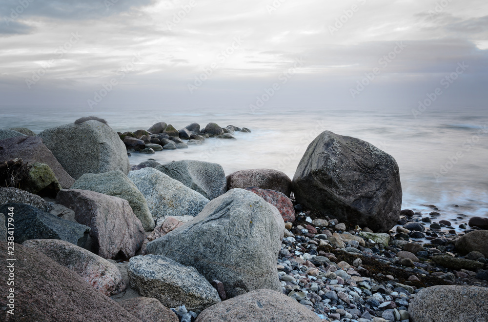 stones on the coast in the sea, soft waves by long time exposure, copy space