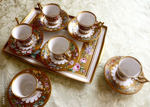 Romantic antique coffee service in Biedermaier style, hand painted in gold and enamel with colorful flowers photo