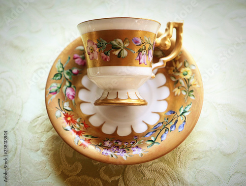 Romantic antique coffee cup with saucer in Biedermaier style, hand painted in gold and enamel with colorful flowers photo