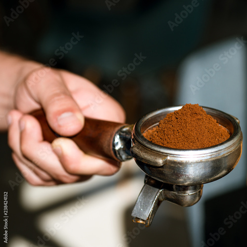 Aroma to kick start and energise your day. Barista brews espresso coffee in cafe. Coffee making in coffeehouse. Brewing coffee equipment. Fresh ground coffee. Barista hold portafilter in hand