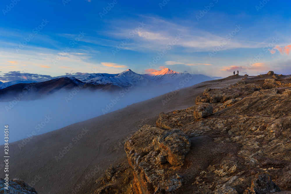 Two photographers and a dog meet the dawn in the mountains