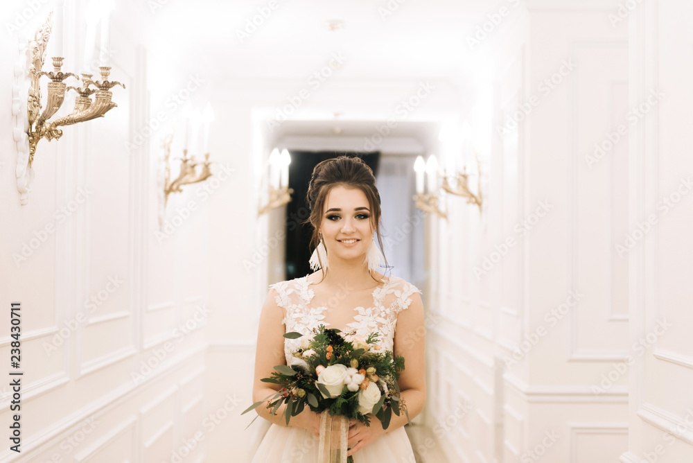 Portrait of an attractive young bride with a winter bouquet. Morning bride in a luxury hotel Portrait of an attractive young bride with a winter bouquet. Morning bride in a luxury hotel