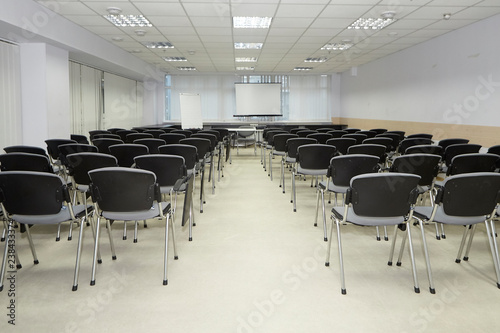 Lecture hall with seats for people. On the stage desks for teachers speaker photo