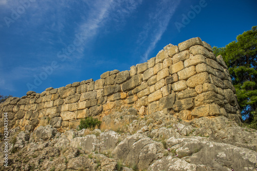 stone wall construction building landmark object ancient Roman Empire heritage on rock environment landscape place, clear weather, empty vivid blue sky, sightseeing tourist concept 