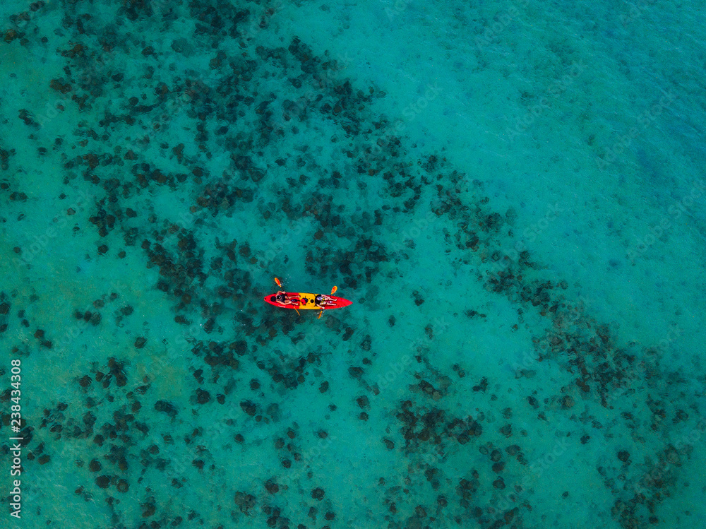 Aerial photography of a red and yellow Kayak in the middle of the ocean with crystal clear water. Koh Phi Phi, Thailand - Asia - Drone view Aerial photography of a red and yellow Kayak in the middle of the ocean with crystal clear water. Koh Phi Phi, Thailand - Asia - Drone view