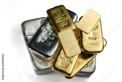 Several cast and minted gold bars and silver cast bars isolated on white background. Selective focus.