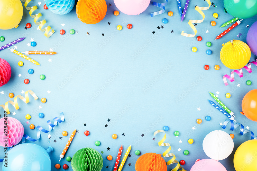 Birthday party background on blue. Top view. Frame made of colorful serpentine, balloons, candles, candies and confetti. - obrazy, fototapety, plakaty 