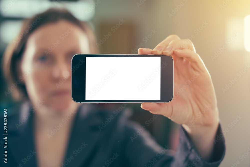 Businesswoman holding smartphone with blank mock up screen