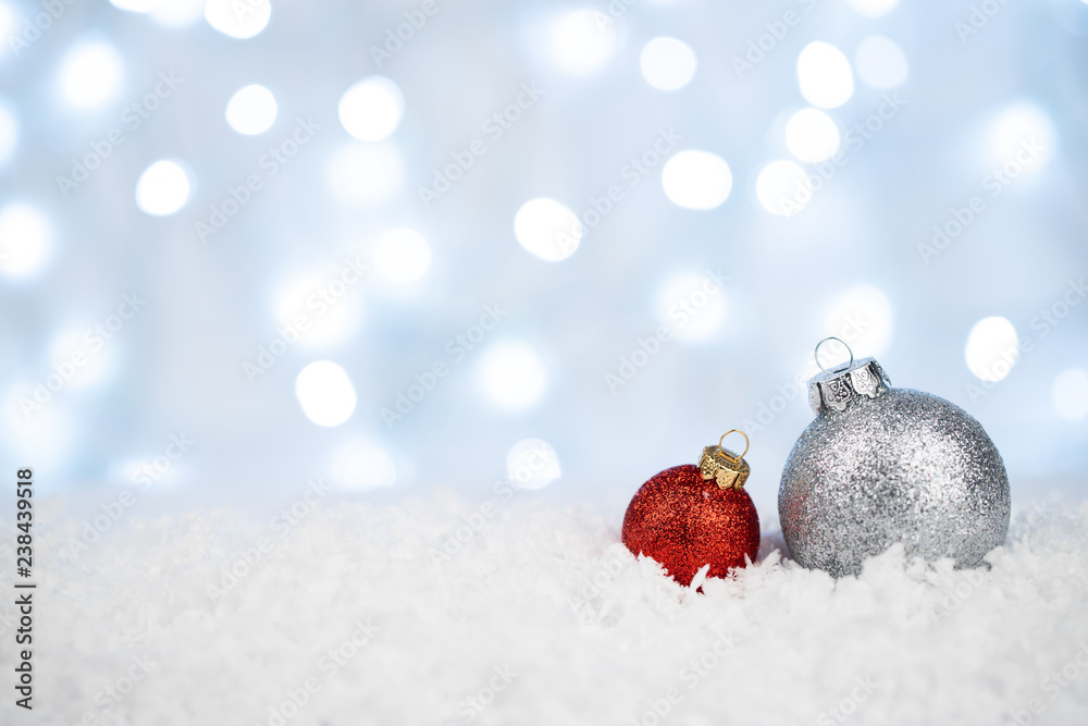 Silver and red Christmas balls on snow with defocused lights Silver and red Christmas balls on snow with defocused lights