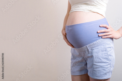 Young pregnant woman with orthopedic support belt