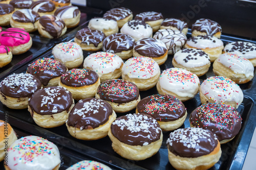 assorted donuts with chocolate frosted, pink glazed and sprinkles donuts
