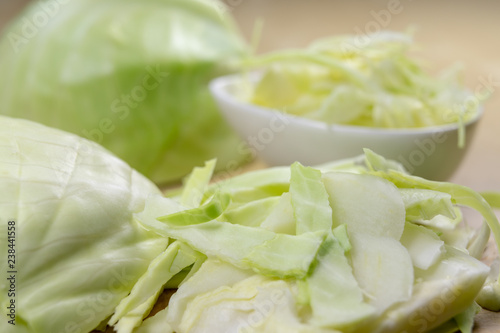 Fresh white cabbage cut into strips on the kitchen table. Vegetables prepared for salad.
