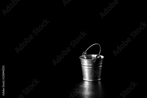 Metal bucket on black background
