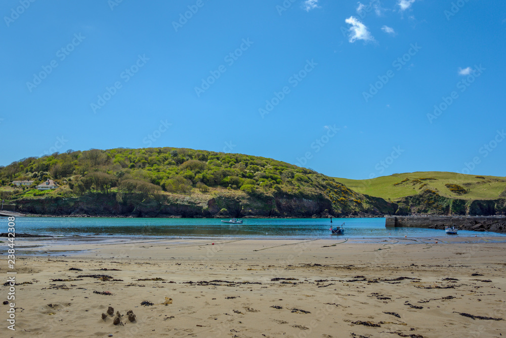 A view of the harbour at Hope Cove South Devon UK from the sandy beach on a sunny spring day