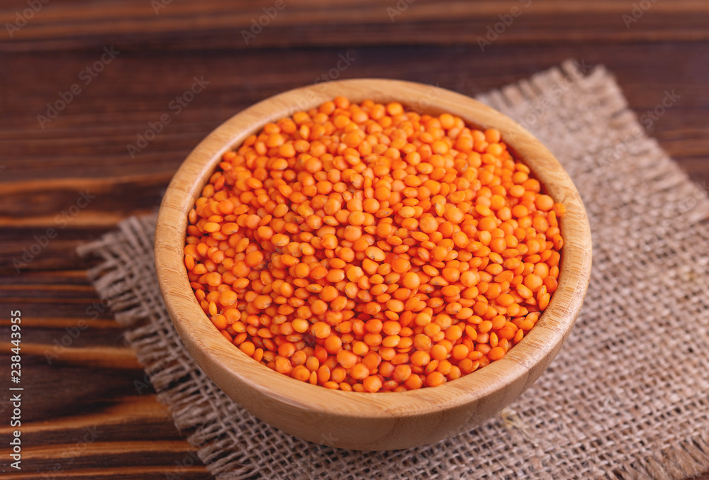 Raw red lentils in wooden bowl with burlap napkin Raw red lentils in wooden bowl with burlap napkin