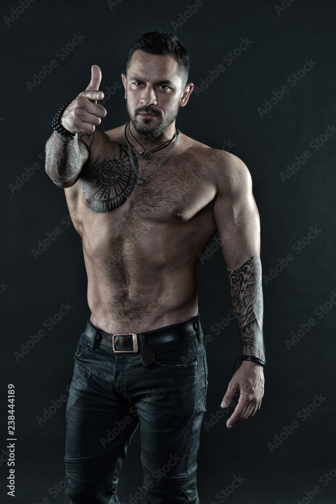 Man brutal unshaven hispanic appearance tattooed arms. Brutal strict macho with tattoos. Masculinity and brutality. Tattoo culture concept. Tattoo brutal attribute. Bearded man show tattooed torso